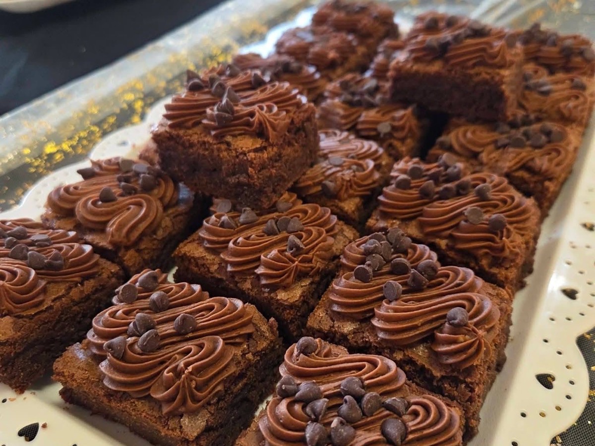 Chocolate brownies topped with frosting swirls and chocolate chips