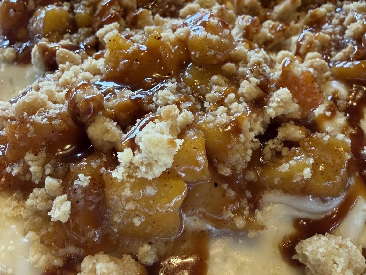 Close-up of peach cobbler with caramel drizzle and crumble